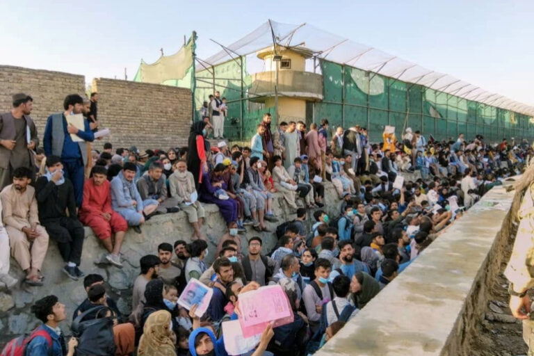 Crowds of people wait outside the airport in Kabul