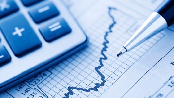 Close-up of a Calculator and Pen on a Financial Newspaper.  Blue-toned